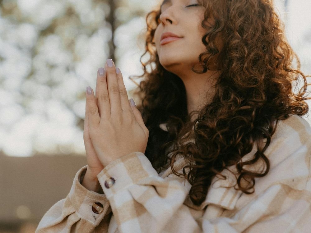 Pessoa em oração com fé, simbolizando transformação espiritual e crescimento pessoal
