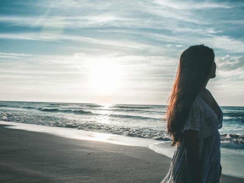 pessoa caminhando ao pôr do sol tranquila, representando superação emocional