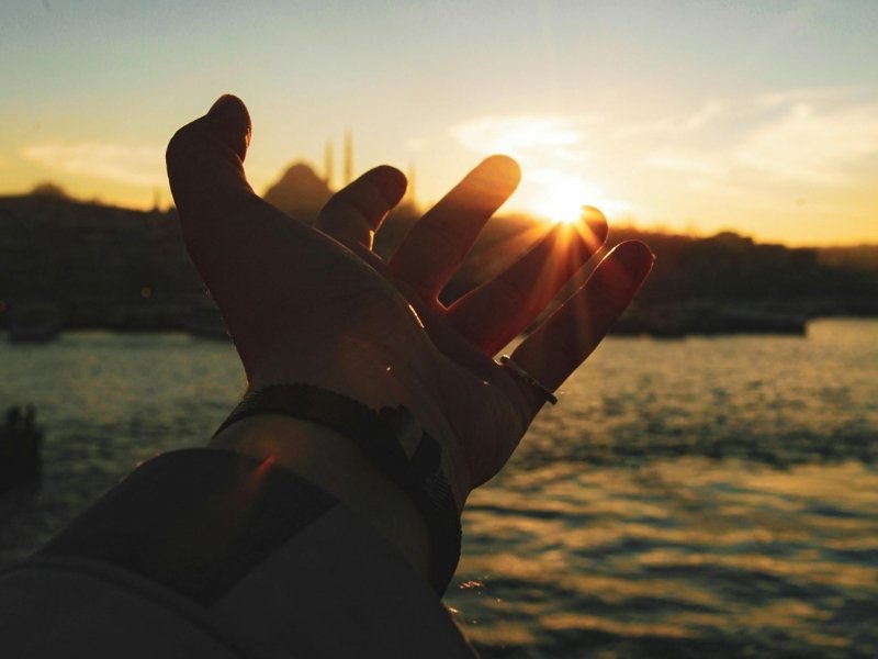 Mãos em oração iluminadas pela luz, representando a fé como prática diária e conexão com Deus.