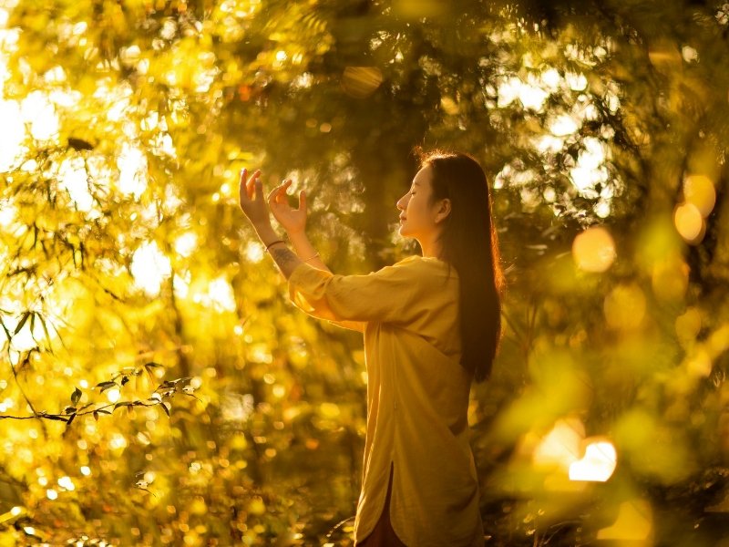 Pessoa em paz ao pôr do sol, símbolo de conexão espiritual.